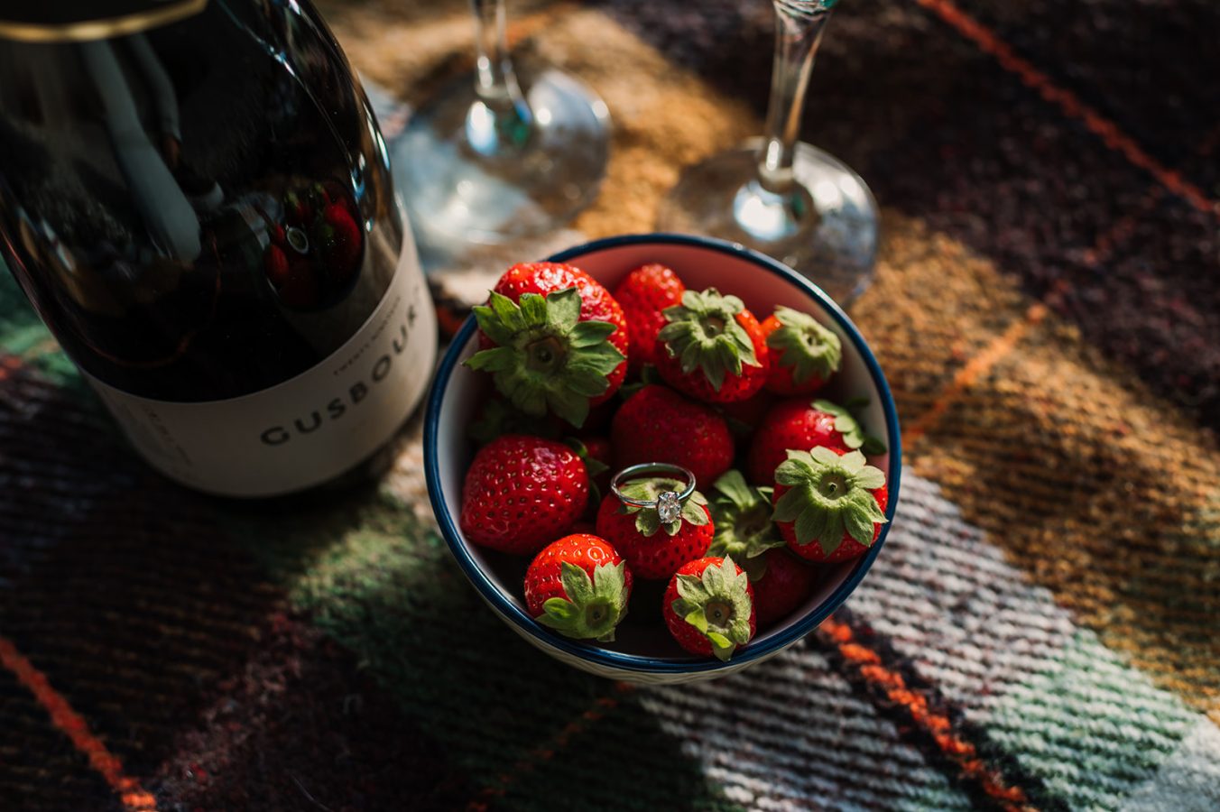 Photo of engagement ring with champagne and strawberries